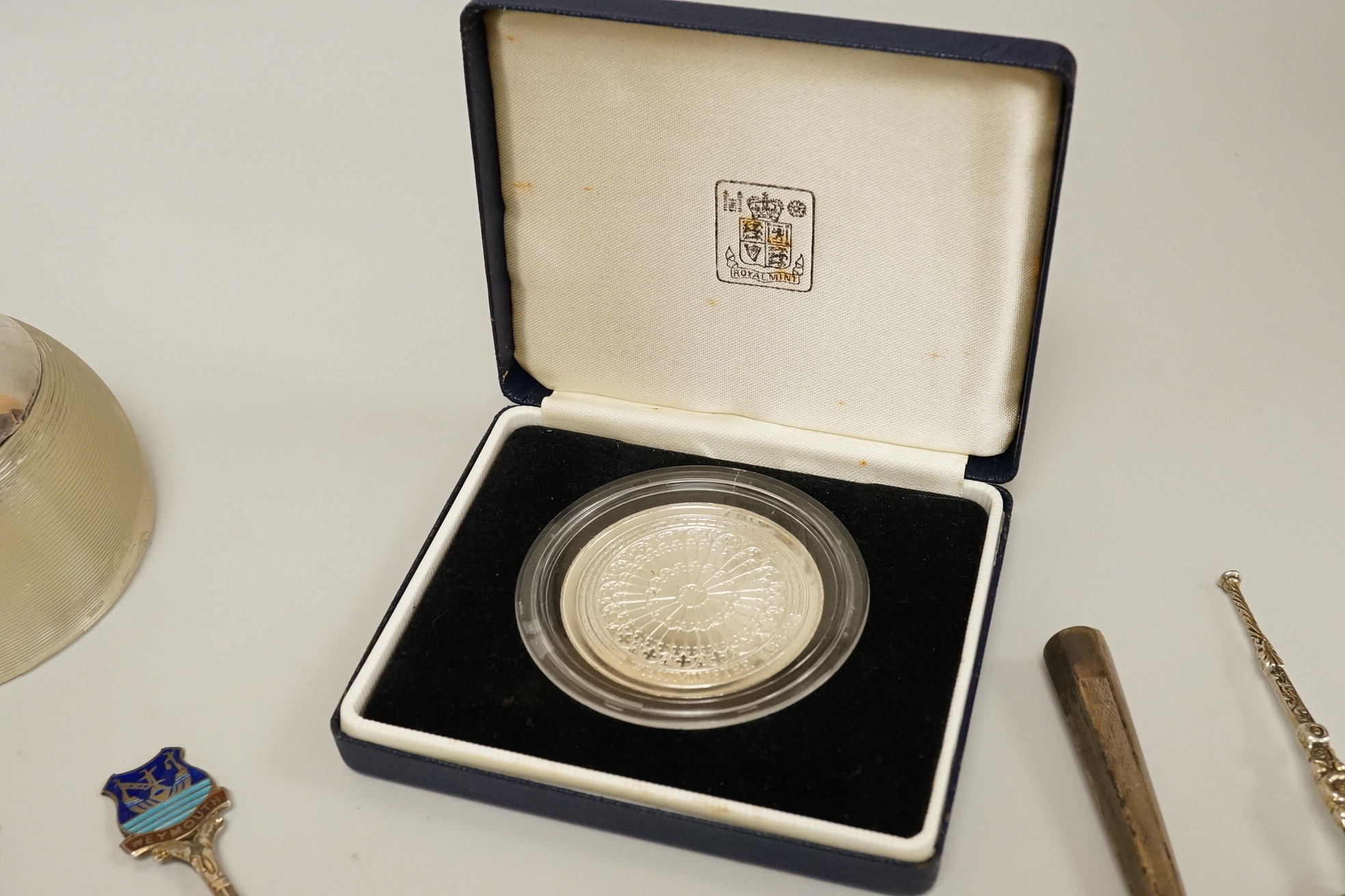 Assorted small silver including a mounted ribbed glass match strike, height 40mm, a small Scottish sterling spoon by Hamish Dawson Bowman, 76mm, a pair of George IV silver sugar tongs, commemorative spoons, an early 20th